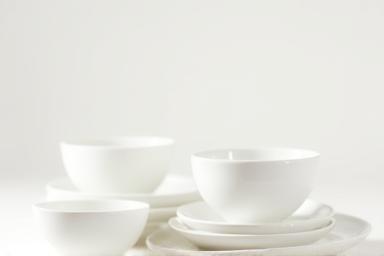 Elegant set of white ceramic plates and bowls.